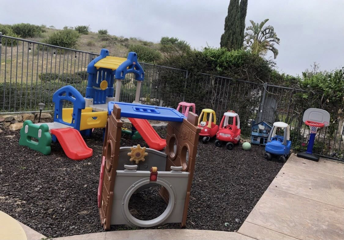 Outdoor playground with climbing structures and ride-on toys